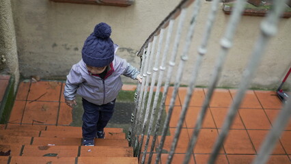 Toddler boy going up the stairs. Baby child goes up the stair during winter season