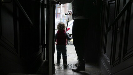 Mother and baby child stepping outside. Parent and toddler going out opening front door