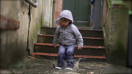 Little baby toddler jumping into water puddle5