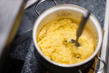 Mashing potatoes with a hand in a pot - sometimes called smashed potatoes