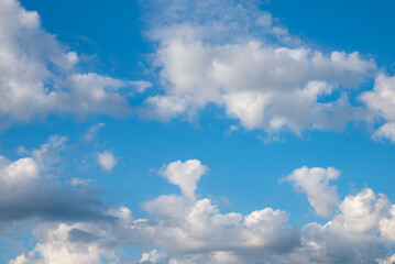 Fototapeta na wymiar cloud scape with fluffy cumulus clouds, one in a heart shape