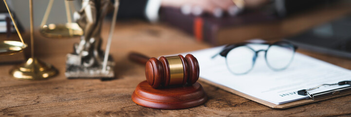Professional Asian female lawyer or legal advisor sitting at her desk holding hands on books on justice concept Sections in the law that govern the conduct.
