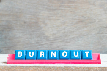 Tile alphabet letter with word burnout in red color rack on wood background