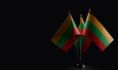 Small national flags of the Lithuania on a black background