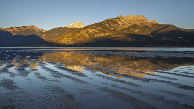 Timelapse of a sunrise with the sun creeping over the mountains in Jasper National Park, Canada