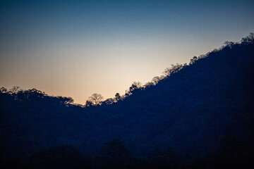 The view of the natural background of the mountain close-up, with blurred fog scattered in the rainy season or the humid climate, with beautiful green trees in the ecological system