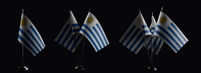 Small national flags of the Uruguay on a black background