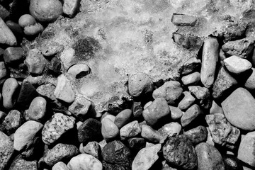 Black and white photo of frozen snow on small rocks
