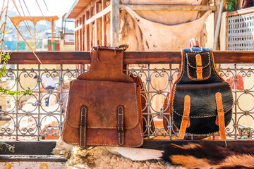 Two leather backpacks exposed for sale on terrace with a tannery view in Fes, Morocco, Africa