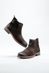 Flying men brown suede casual style boots over white background. side view. Copy space for ad, design, text.