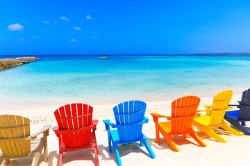 Colorful wooden chairs on white sand beach in Aruba, Duth Caribbean