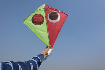 Boy flying kite on terrace. person flying patang on Indian kite festival celebrations on house...