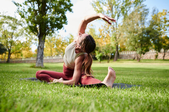 Woman in process of doing seated gate asana