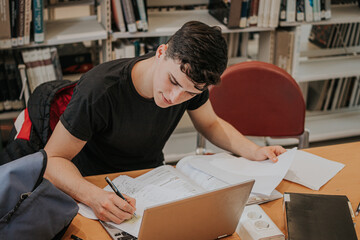 Concentrated teenager writing notes during studies