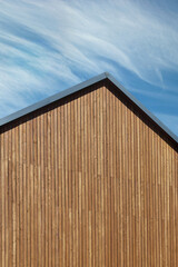 Fototapeta premium Roof construction with wooden plank gable on a new modern home. Copy space, vertical