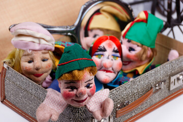 some punch puppets sitting inside a vintage suitcase