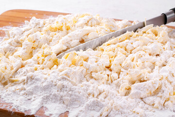 Making chopped pastry dough or quick puff pastry. Cutting the dough with a knife into small pieces