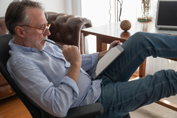 Serious man working on tablet at home