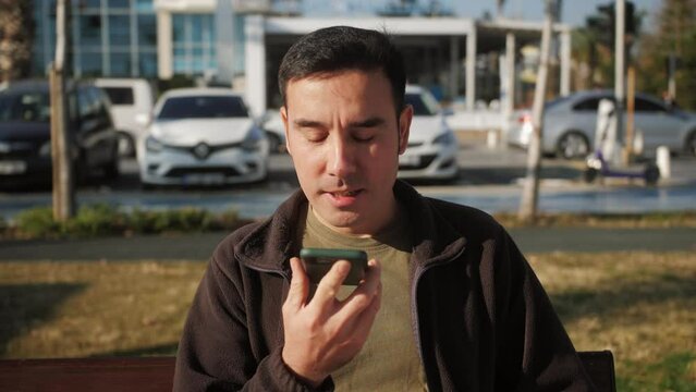 Arab millennial businessman talk on speakerphone with friend makes voice recognition use virtual assistant digital application record audio message on mobile app.
