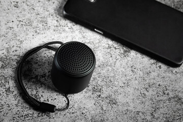 Black mini Bluetooth speaker and smartphone conected.