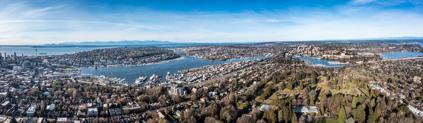 Seattle, Washington - Jan. 2023, panoramic aerial landscape view of the area around Lake Union and Lake Washington in Seattle with Space Needle and snow covered Mountains in background