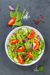 Mixed salad with fresh tomatoes healthy eating food from above portrait format on a slate
