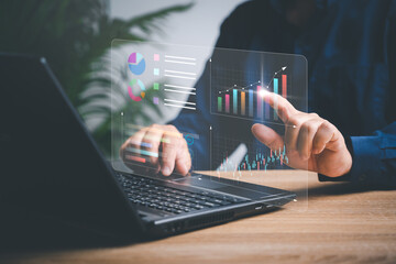 Businessman working on laptops to smart digital marketing on virtual screen, Analyzes the profitability of working companies with digital augmented reality graphics, and develop the organization