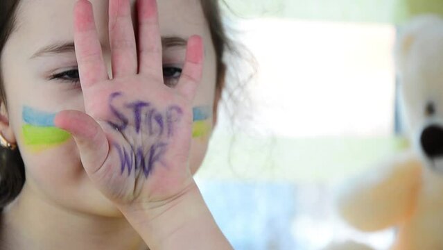 Children against war. Ukrainian child prays for peace. War in Ukraine. Girl with Ukrainian symbols. Destruction during the war in Ukraine. Peace concept. Ukrainian children. The shelling of Ukrainian 