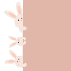 Cute Easter bunnies peeking out from behind the beige wall