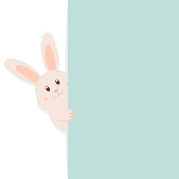 Cute Easter bunny peeking out from behind a turquoise wall