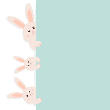 Cute Easter bunnies peeking out from behind the green wall