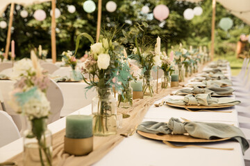 gedeckte Hochzeitstafel mit goldenen Platztellern frischen Blumen und Leinenservietten - 560464340