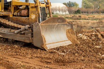 Dozer working at construction site. Bulldozer for land clearing, grading, utility trenching and foundation digging. Crawler tractor and earth-moving equipment © alicobanoglu