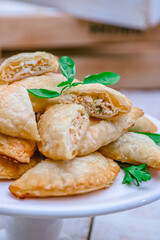 Empanadas typical latin food, Argentina. Delicious and juicy. White wood background with vegetables around