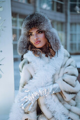 Outdoor close up portrait of young beautiful happy smiling girl with red lips, wearing in a fur...