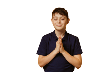Cute caucasian boy in casual dark blue t-shirt stands against transparent background in praying pose with eyes closed. Christmas wishes. Hope concept. Mock up, wishing a gift. Expecting present