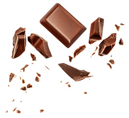  Levitating milk chocolate chunks isolated on white background. Flying Chocolate pieces, shavings and cocoa crumbs Top view. Flat lay.