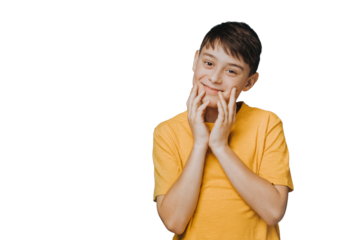 Cute handsome boy in yellow t-shirt touching his face, looking with tenderness, feels caress, happy to be healthy and have a good friends, posing over transparent background with empty space.