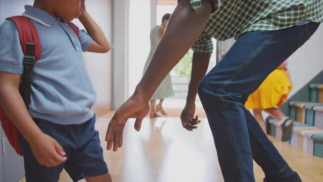 Parents helping daughter to put on backpack as they leave house through front door and go to school together - shot in slow motion