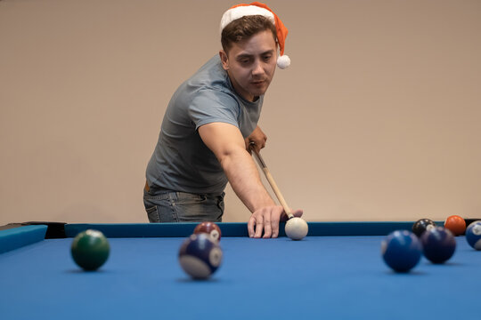 A Man In A Santa Hat Holds His Hand On A Pool Table, Plays Snooker Or Prepares To Shoot Billiard Balls, Port Game Snooker Billiards, Billiard Balls, Play Billiards