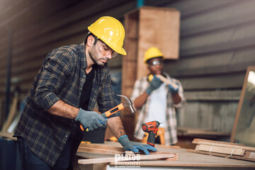 Young adult men carpenter craftman working in small business wood workshop. Timber industry and...