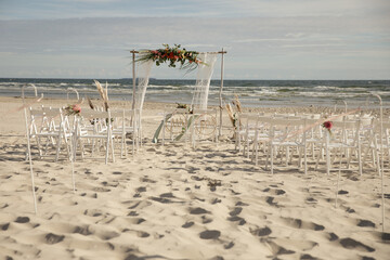 Strandhochzeit an der Ostsee mit Traubogen Makramee und frischen Blumen - 560469714