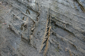 Dirt road after heavy rain. Traces of car tires on a dirt road after rain. Traces of automobile wheels in liquid mud. driving hazard