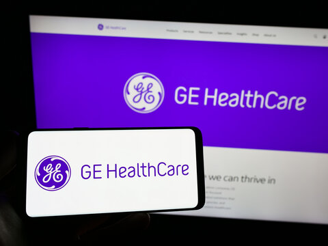 Stuttgart, Germany - 01-06-2023: Person holding smartphone with logo of US company GE HealthCare Technologies Inc. on screen in front of website. Focus on phone display.