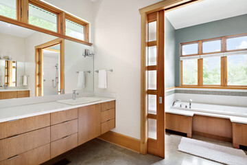 Styled Home Still Lifestyle Image. Vintage Bathroom with Soaking Tub and Wooden Privacy Doors. Light Soaked Bathroom with Double Vanity and Large Mirror.