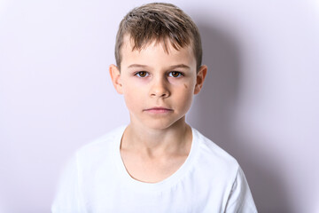 portrait of handsome young boy posing near the white wall