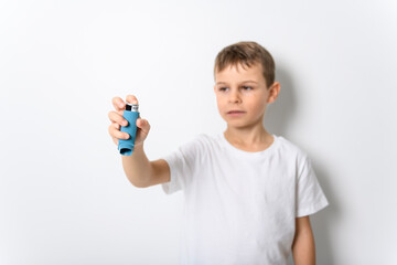 little boy using inhaler for asthma over white background