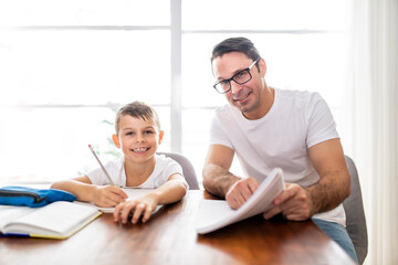 Father and son doing homework together at home