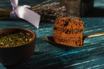 Still life with a piece of cake and morning tea - a delicious breakfast on a dark background