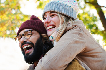 Close up portrait of lovely couple hugging. Young bearded man with glasses giving his blonde cute...